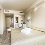 Juniorsuite im Hotel mit einem großen Bett, Fernseher und modernem Dekor in hellen Farben.