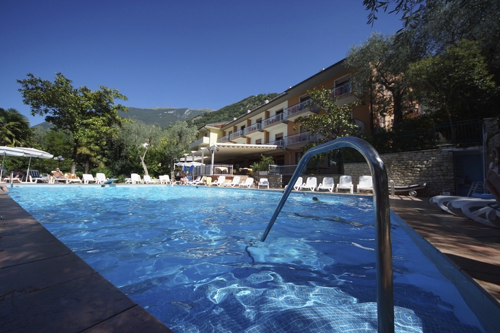 Hotelpool mit Liegestühlen und umgebener Natur in Malcesine.