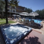 Hotelpool mit Liegestühlen und Whirlpool in Malcesine bei sonnigem Wetter.