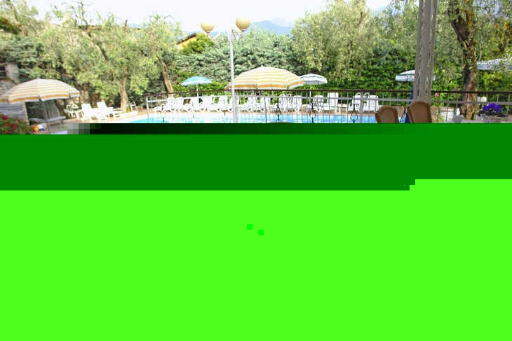 Frühstückstisch auf Terrasse mit Blick auf Pool und grüne Umgebung.
