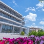 Modernes Hotelgebäude mit Blumen im Vordergrund in Peschiera del Garda.