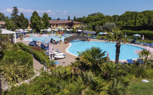 Außenpool des Hotel Bella Italia mit Liegestühlen und Sonnenschirmen.