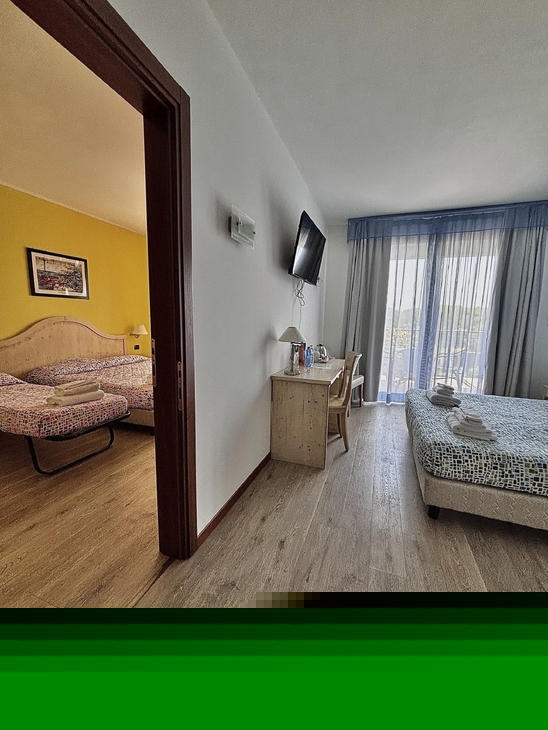 Familienzimmer mit Verbindungstür und zwei Betten im Hotel Bella Italia.