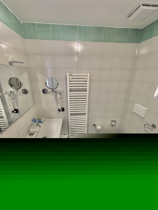 Badezimmer mit Waschbecken, WC, Bidet und Handtuchhalter.