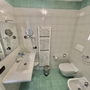 Badezimmer mit Waschbecken, WC, Bidet und Handtuchhalter.