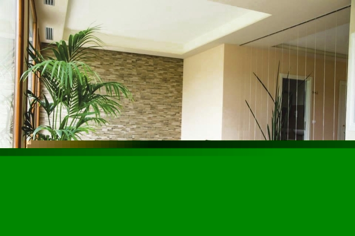 Zwei Liegestühle in einem Spa-Bereich mit Pflanzen und gemauerter Wand.