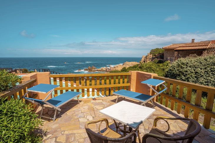 Terrasse mit Sonnenliegen, Meerblick und blauem Himmel in Sardinien, Hotel Costa Paradiso.