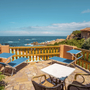 Terrasse mit Sonnenliegen, Meerblick und blauem Himmel in Sardinien, Hotel Costa Paradiso.