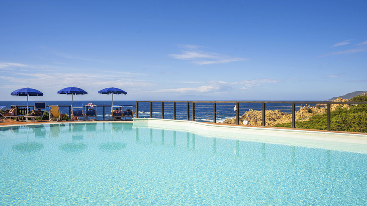 Pool mit Meerblick, blauer Himmel und Sonnenschirme im Hotel Costa Paradiso, Sardinien.