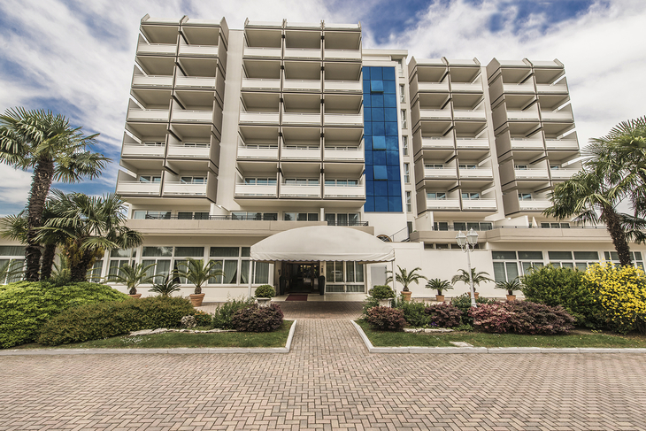 Eingang des Hotel Des Bains Terme mit moderner Fassade und Palmen.