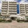Eingang des Hotel Des Bains Terme mit moderner Fassade und Palmen.