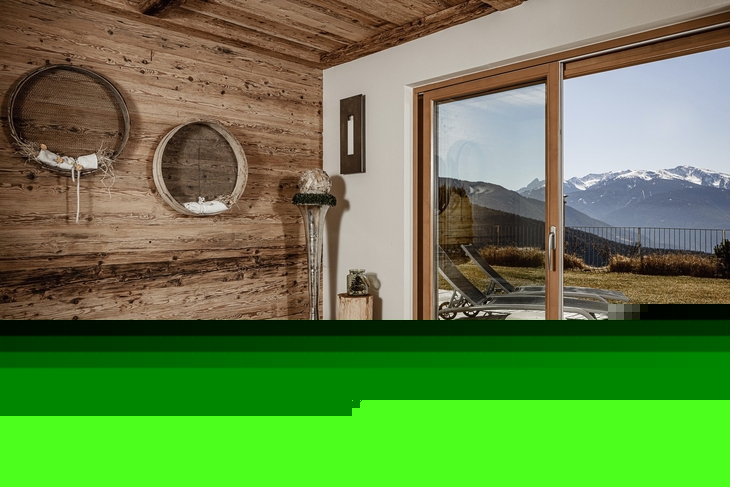 Ruheraum mit Holzverkleidung, Liegen und Bergblick durch große Fenster.