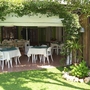 Gartenrestaurant mit weiß gedeckten Tischen und grünen Pflanzen.