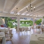 Ein heller Restaurantbereich mit gedeckten Tischen und Blick auf einen Garten.