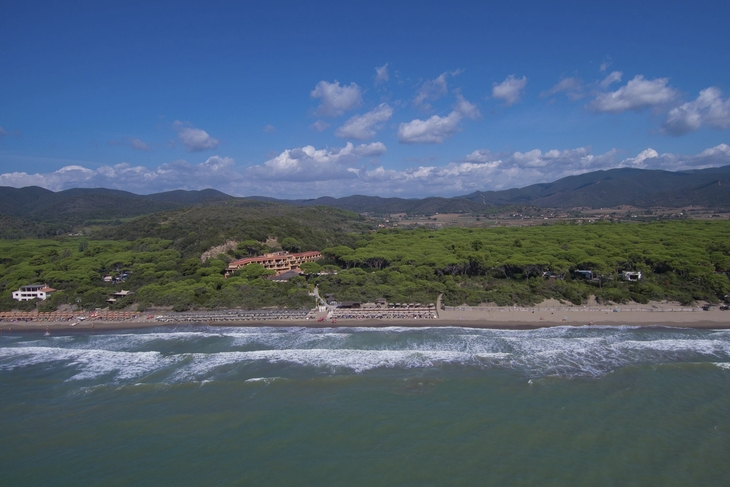 Luftaufnahme eines Küstenresorts mit grüner Umgebung und Strand.