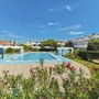 Pool und Ferienhäuser bei strahlend blauem Himmel im Villaggio Maja, Bibione.