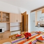 Essbereich in einer Ferienwohnung mit gedecktem Tisch und moderner Küchenzeile