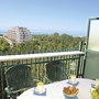 Balkon mit Tischen und Stühlen, Blick auf Gebäude und Meer in Bibione.