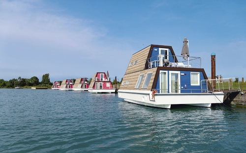 Hausboote auf einem stillen Wasserkanal im Marina Azzurra Resort in Lignano.