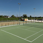 Tennisplatz und Basketballfeld im Freien bei sonnigem Wetter.