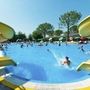 Menschen genießen Schwimmbad mit Rutschen an einem sonnigen Tag.