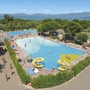 Luftaufnahme von Pools und Rutschen im Campingplatz mit Blick auf einen See und Berge.