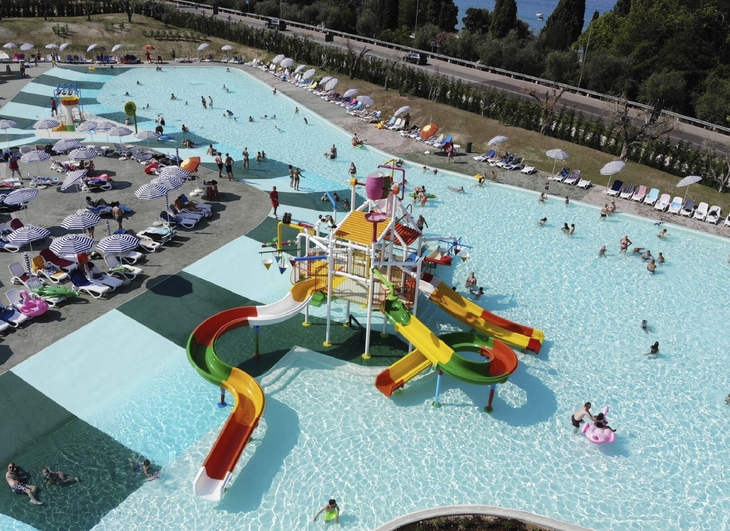 Wasserpark mit Rutschen und Badenden auf Campingplatz.