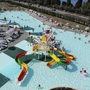 Wasserpark mit Rutschen und Badenden auf Campingplatz.