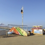 Bunte Strandboote und Liegen am Sandstrand mit klarem Himmel.