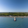 Luftaufnahme eines Strandes mit Pier und umliegendem Grünland.