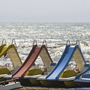Tretboote mit Rutschen am Strand vor welligem Meer bei Sonnenschein