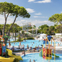 Wasserspielplatz mit Rutschen und badenden Menschen in einer Ferienanlage.