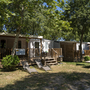 Mobile Homes mit Holzterrassen und Bäumen bei Camping Bella Italia