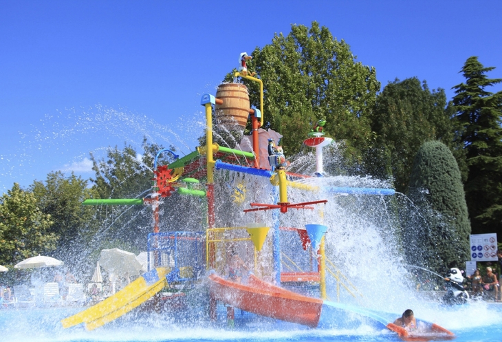 Wasserspielplatz mit bunten Rutschen und spritzendem Wasser.