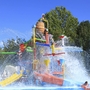 Wasserspielplatz mit bunten Rutschen und spritzendem Wasser.