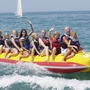 Gruppe von Menschen in Schwimmwesten auf einem Bananenboot auf dem Wasser.
