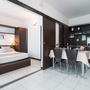 Wohnbereich mit Esstisch, Küche und Schlafzimmer in einem Apartment.