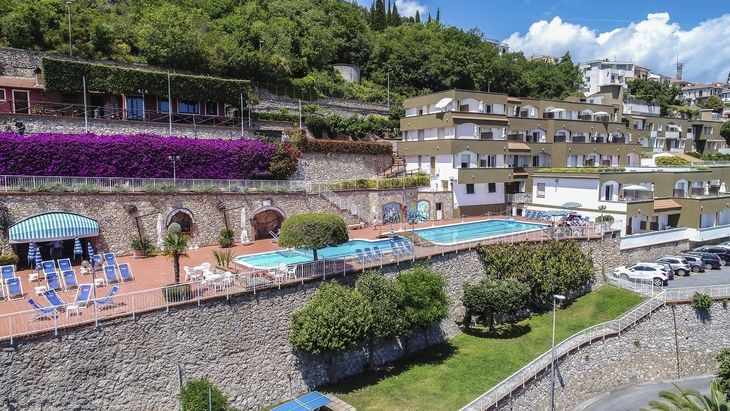 Gebäude und Poolanlage in hügeliger Landschaft bei Sant Anna, Pietra Ligure.
