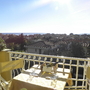 Blick von einem Balkon auf ein Dorf und das Meer im Hintergrund bei sonnigem Wetter.