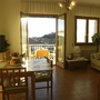 Wohnzimmer mit Esstisch, Fernseher, Sofa und Balkon mit Ausblick.