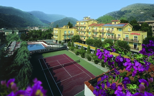 Hotel mit Tennisplatz und Bergkulisse in Pietra Ligure.