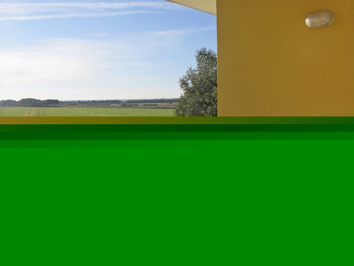 Terrasse mit Tisch, vier Stühlen und Obstschale, Blick auf Feld und blauen Himmel