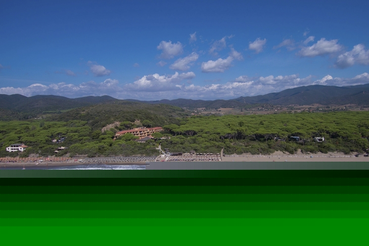 Luftaufnahme eines Küstenresorts mit grüner Umgebung und Strand.