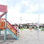 Spielplatz mit farbiger Rutsche im Sandbereich bei Rosa dei Venti.