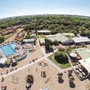 Luftaufnahme eines Ferienclubs mit Pool, Gebäuden und umgebender Landschaft.
