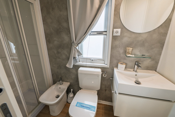 Modernes Badezimmer mit Dusche, Toilette, Bidet und Waschbecken.