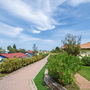 Gartenweg mit Häusern und blauem Himmel in Rosolina Mare.