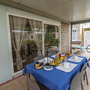 Gedeckter Tisch mit Frühstück auf einer Terrasse, zwei Fahrräder im Hintergrund.