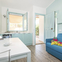 Helle, modern eingerichtete Küche mit Esstisch und Sofa in einem Bungalow.