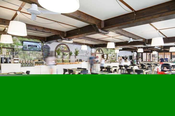 Innenraum eines modernen Restaurants mit Holzelementen und gedeckten Tischen.
